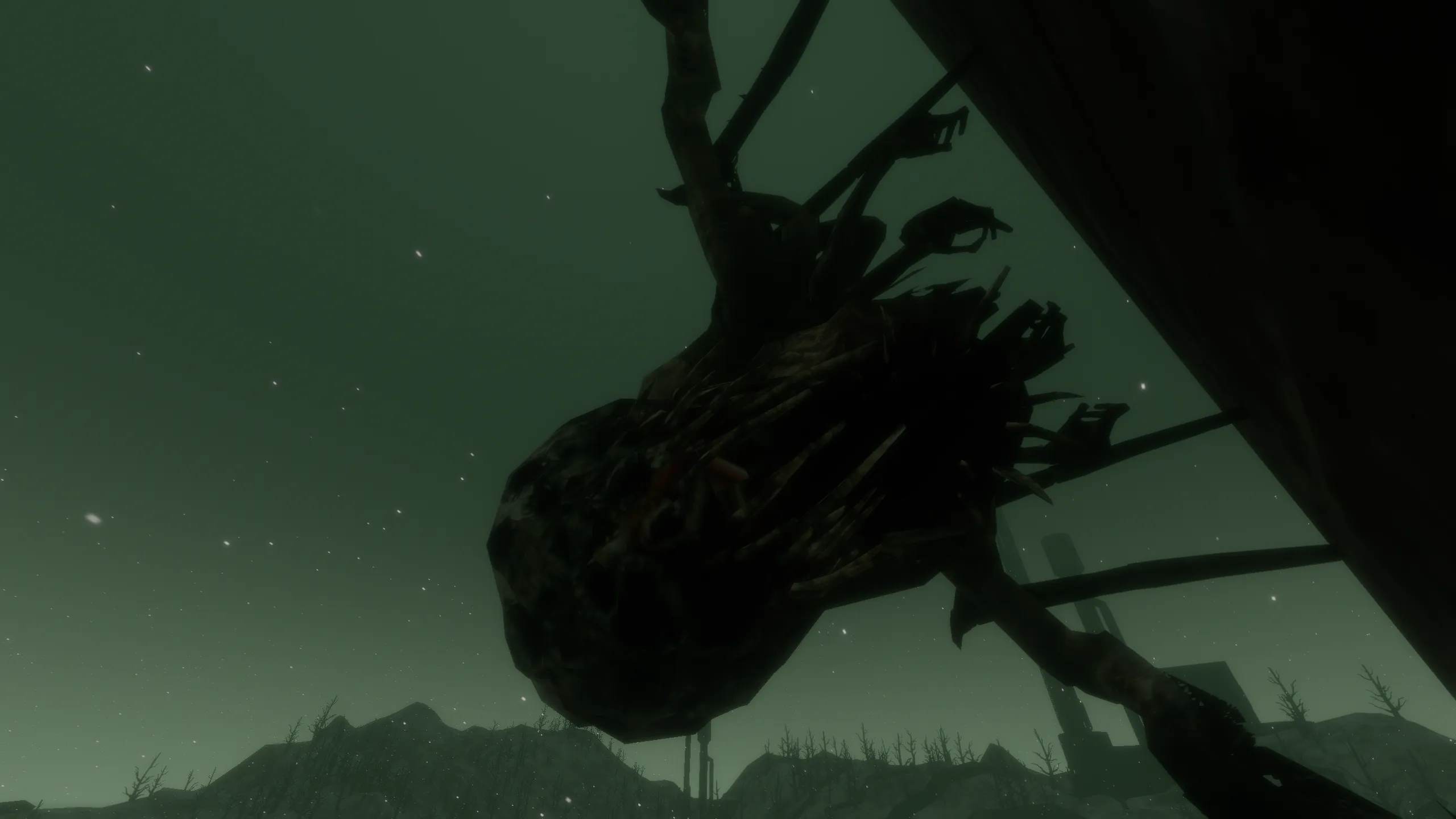A creature hanging from a dead tree in the tundra